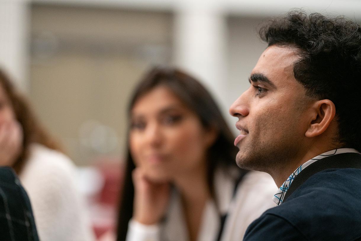 Close up of male student speaking with others