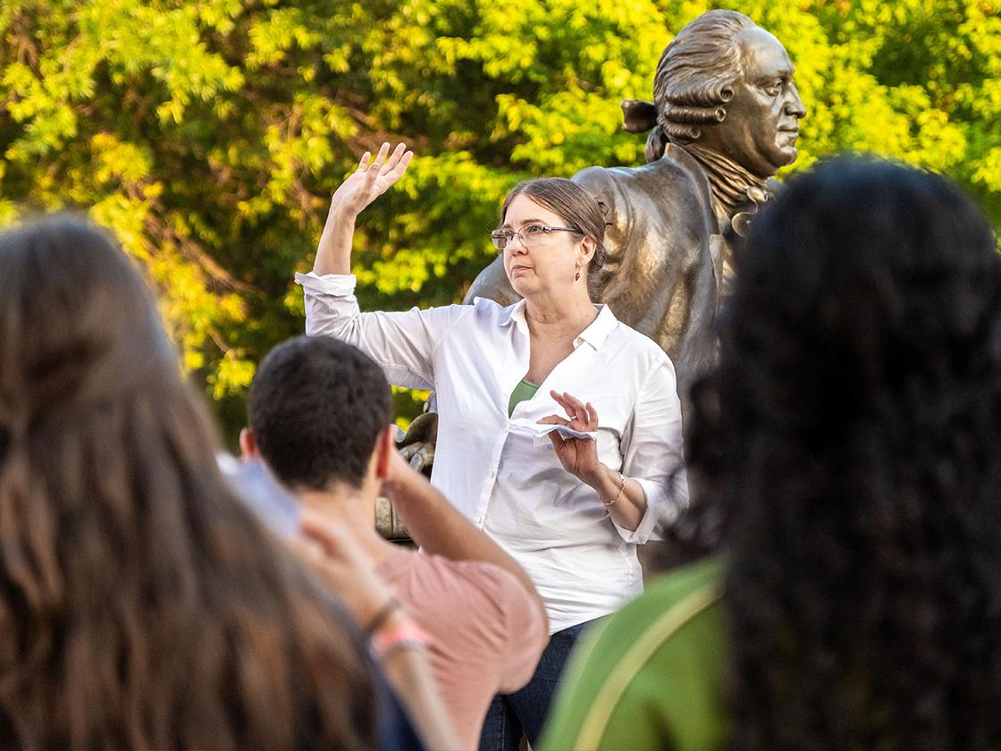 Female professor standing in front of crowd outside