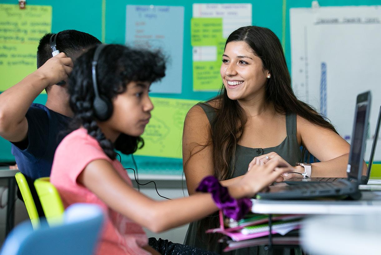 Young teacher aid working with students