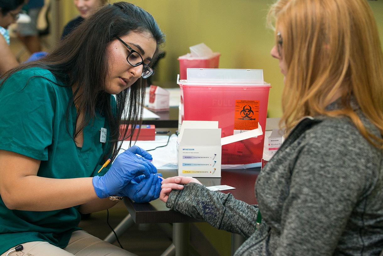 A nursing student taking blood