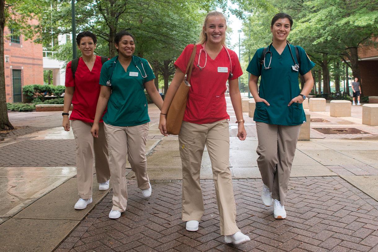 Four nursing students walking outside