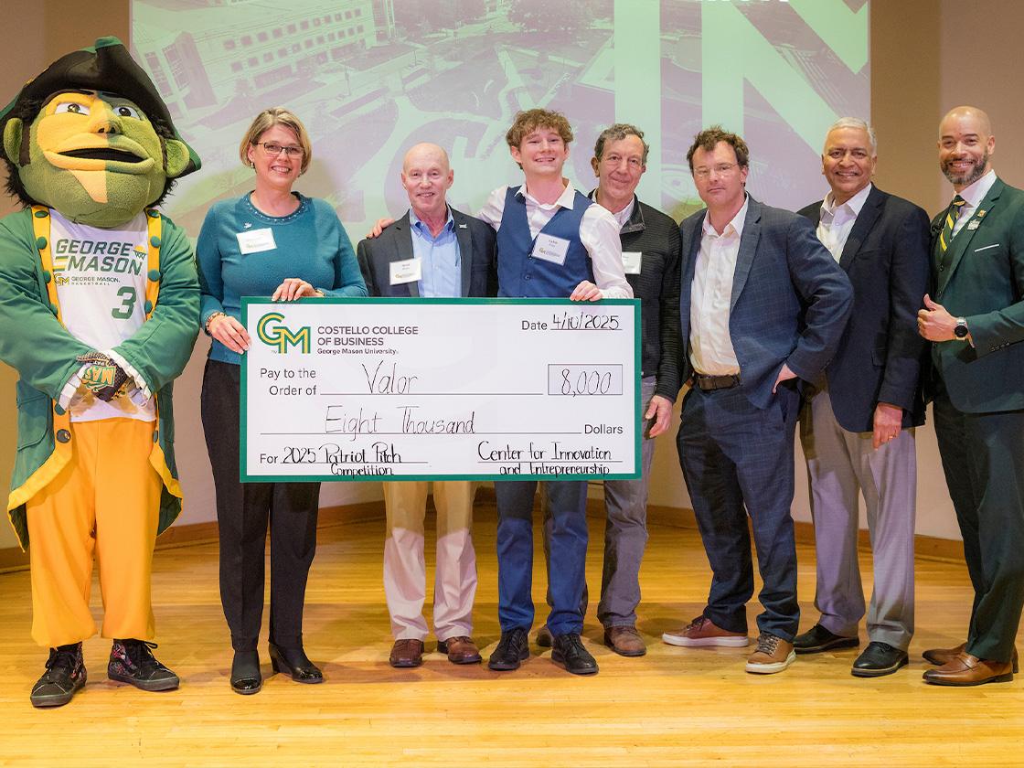 A group of people holding a large check with the mascot