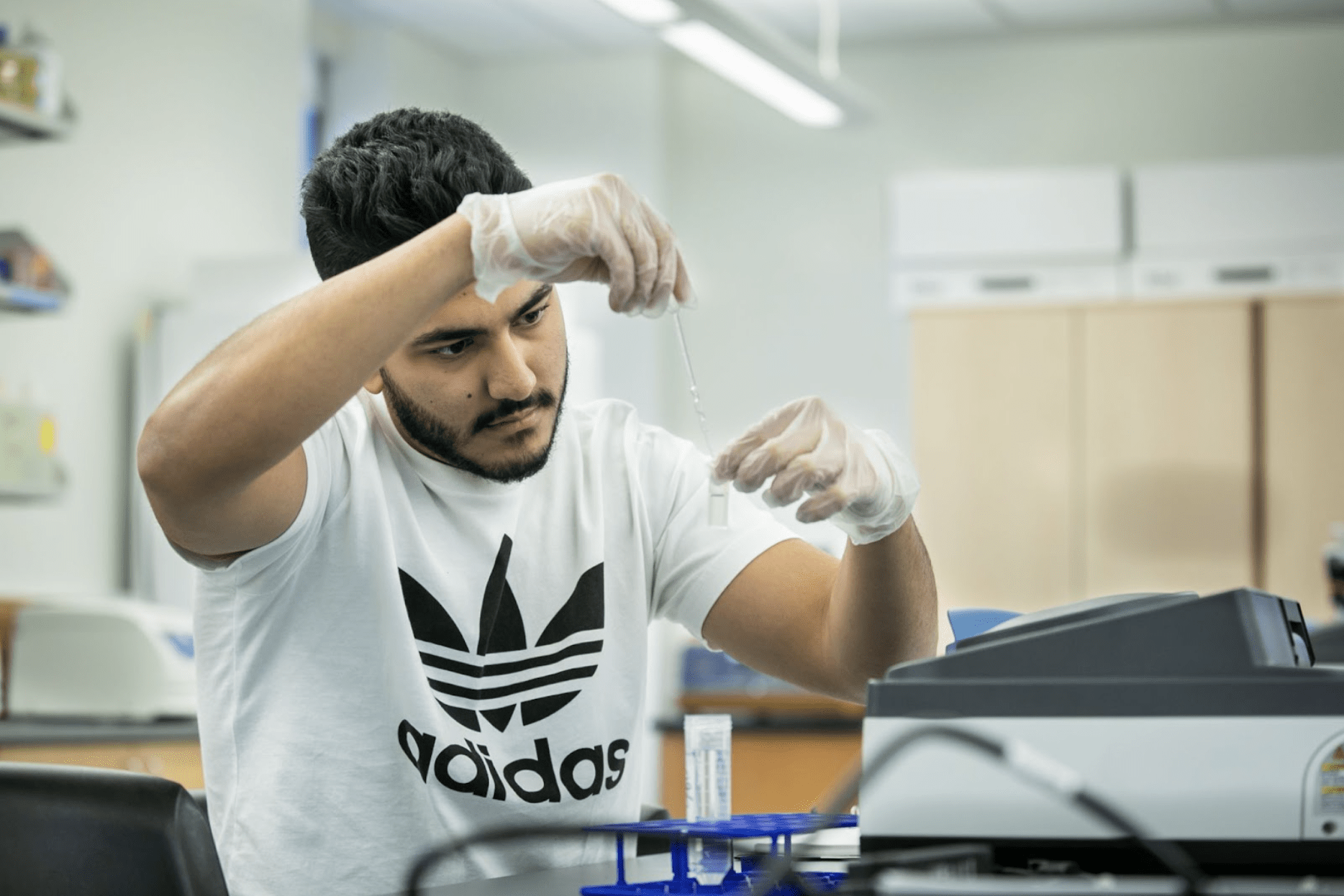 Student wearing gloves and working in a lab