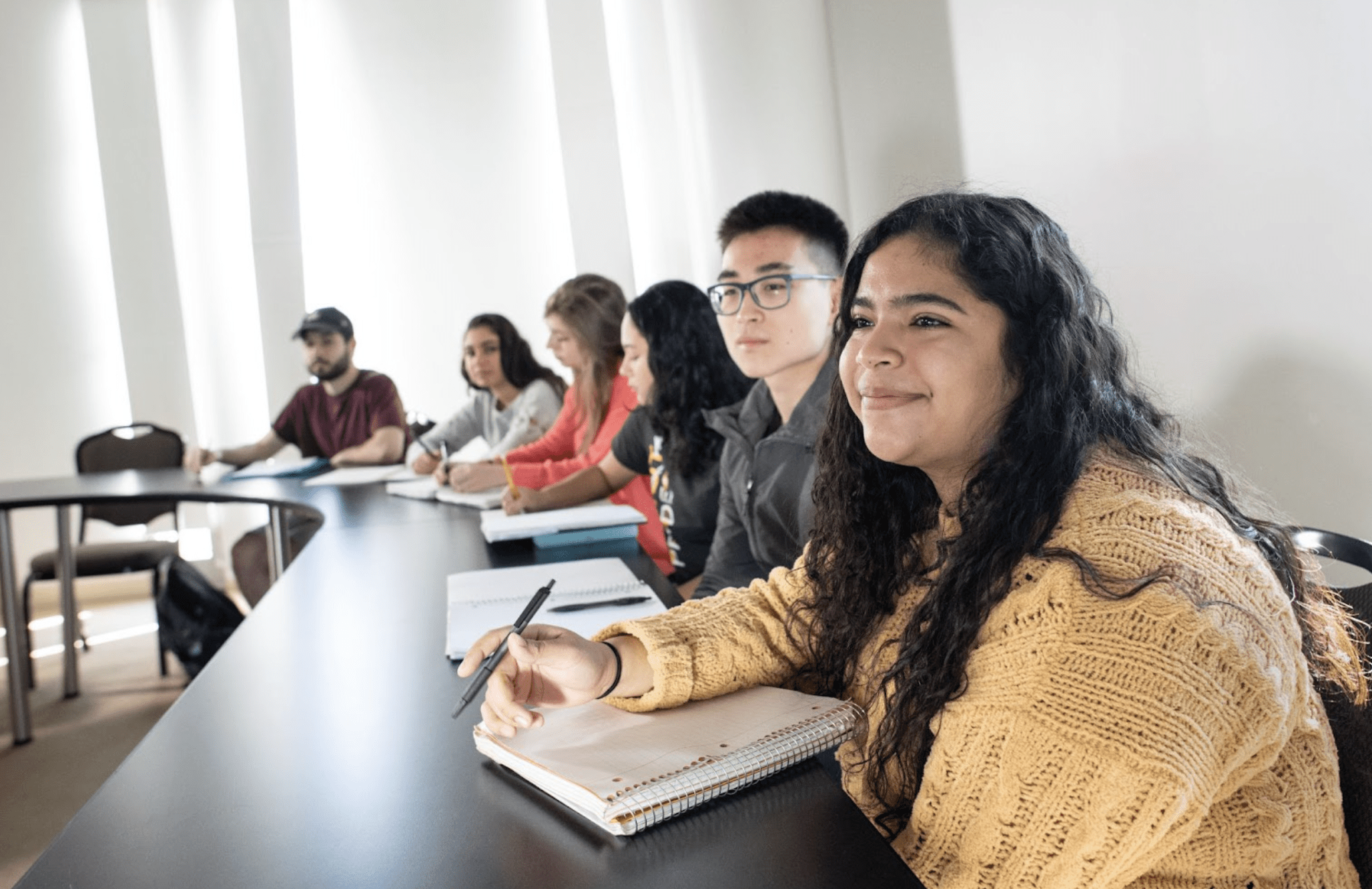 Students sitting behind a long desk