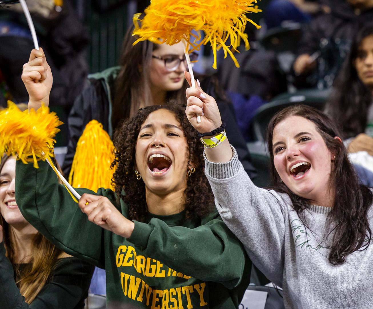 Students cheering with pom poms during a game