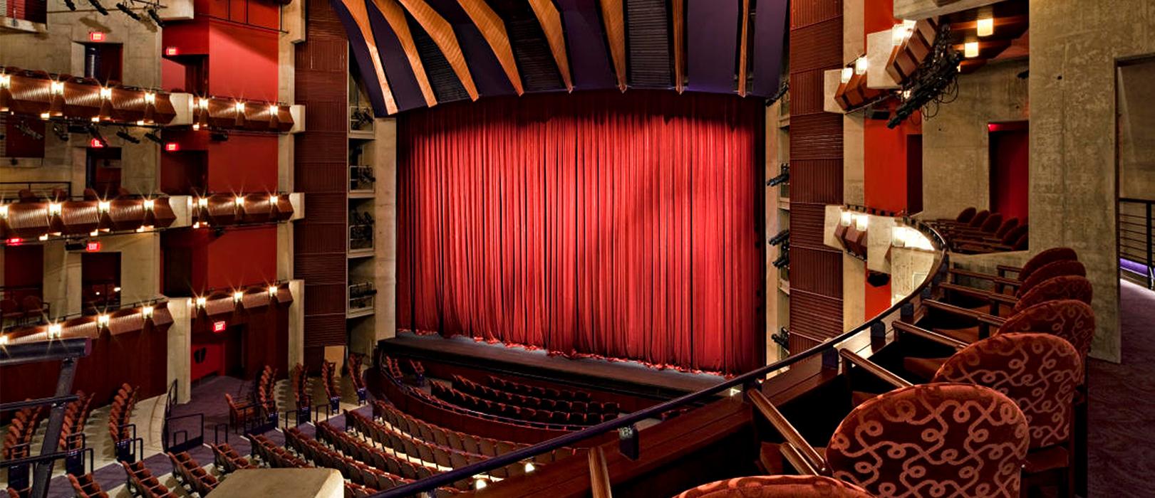 View of a balcony seat in a theatre with a red curtain