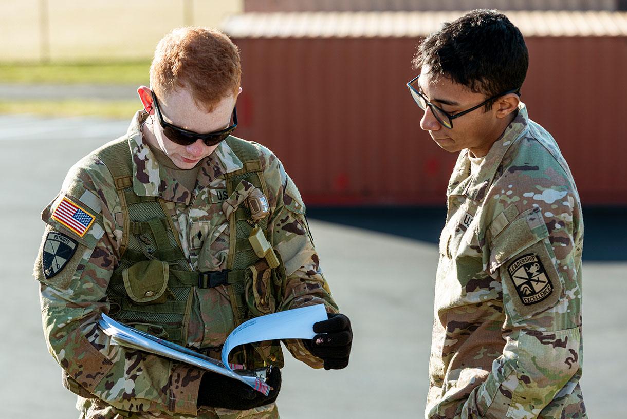 Two soldiers looking at papers together