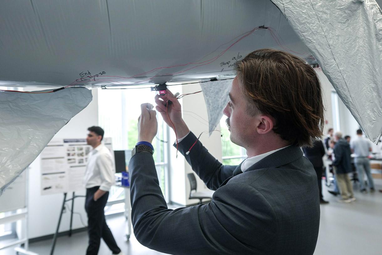 Man in suit and working under large metal robot