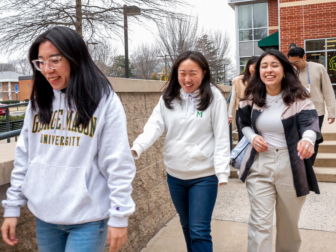 Three students walking together outside during winter
