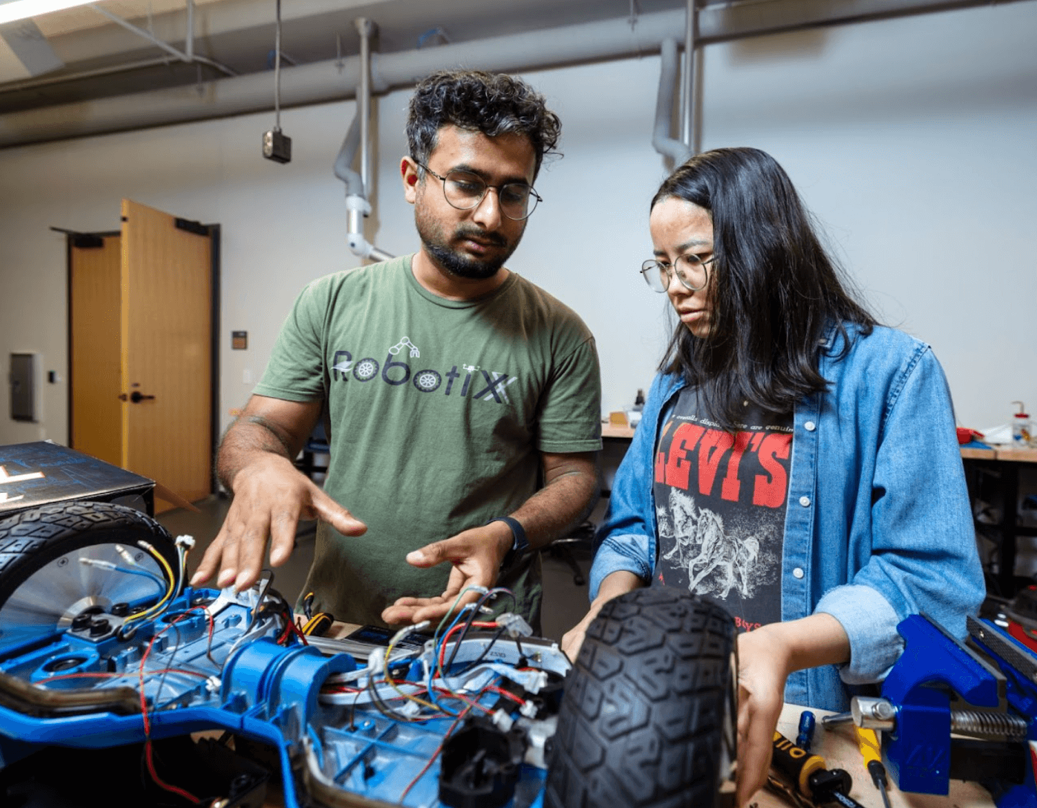 Two people working together on building a robot