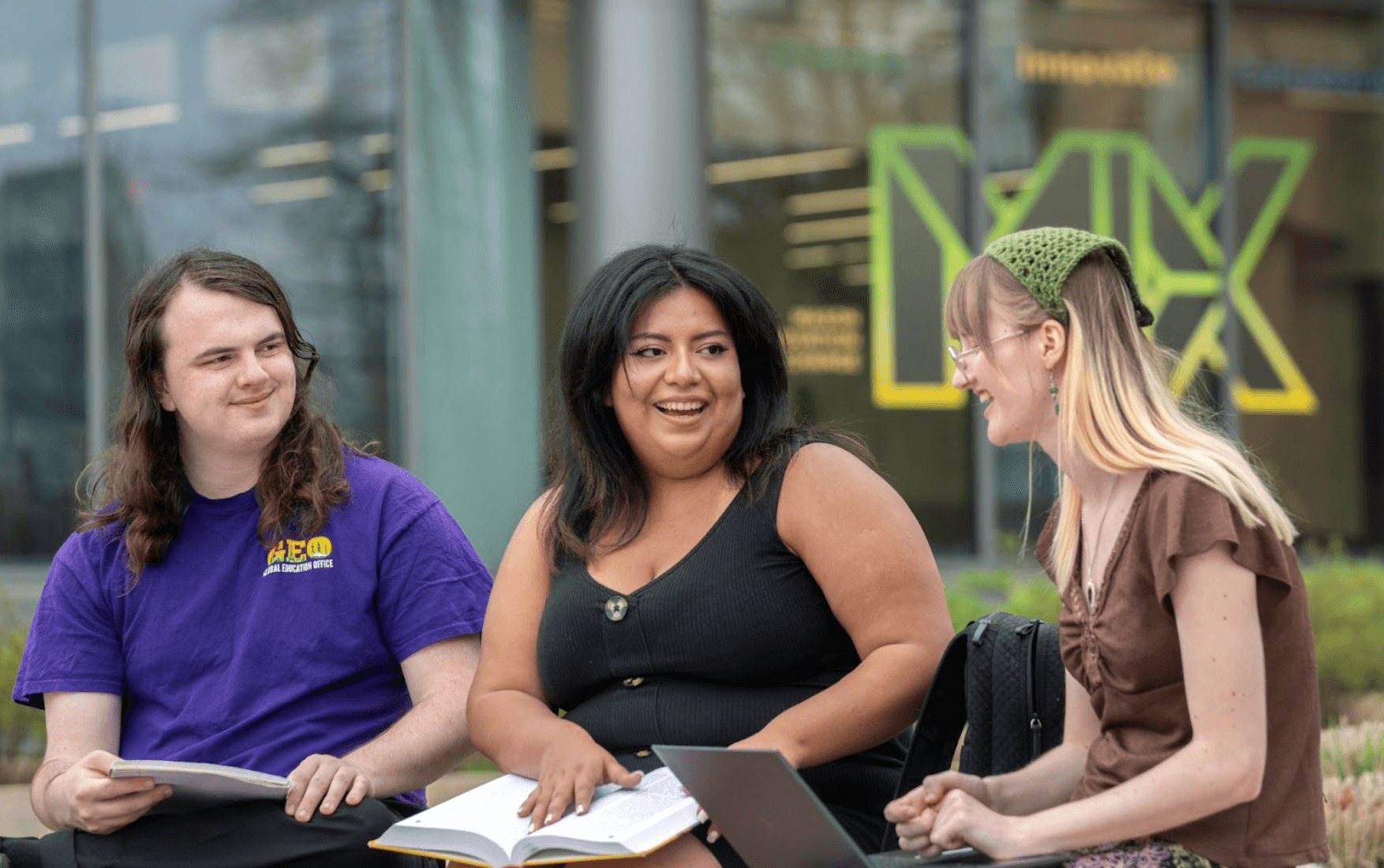 Three students sitting together outside