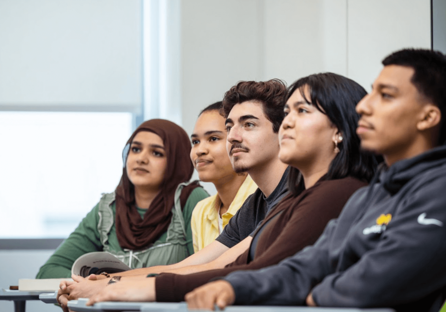 Multiple students sitting at desks and listening