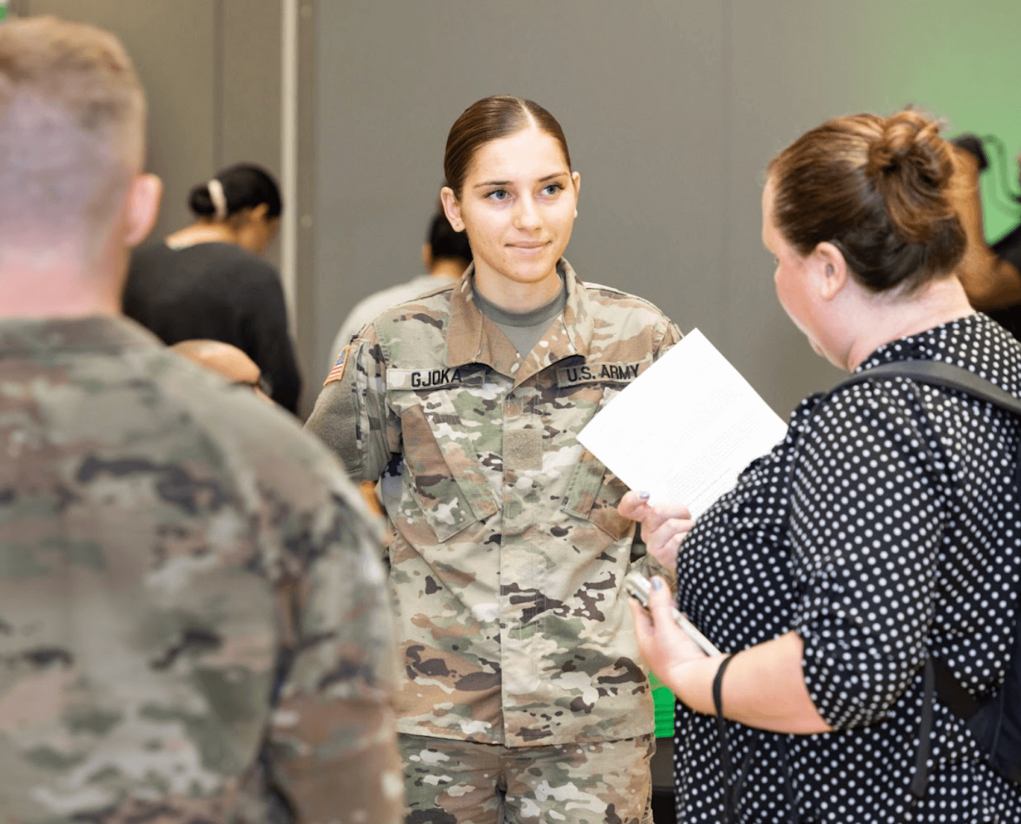 Woman in her military uniform talking to a civilian