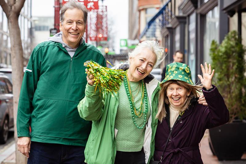 Three smiling alumni wearing green