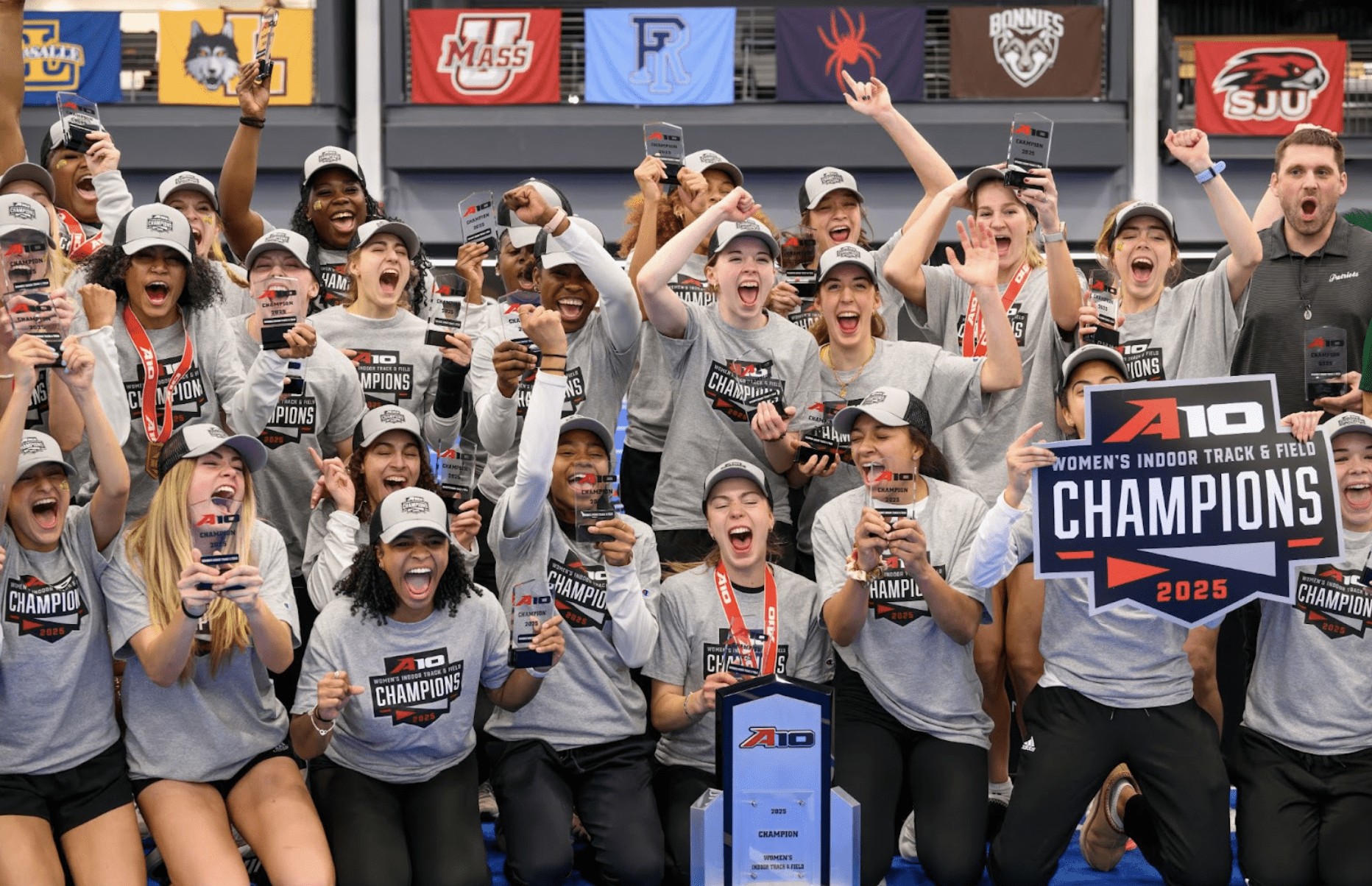 Sports team cheering and wearing grey Champions t-shirts and signage