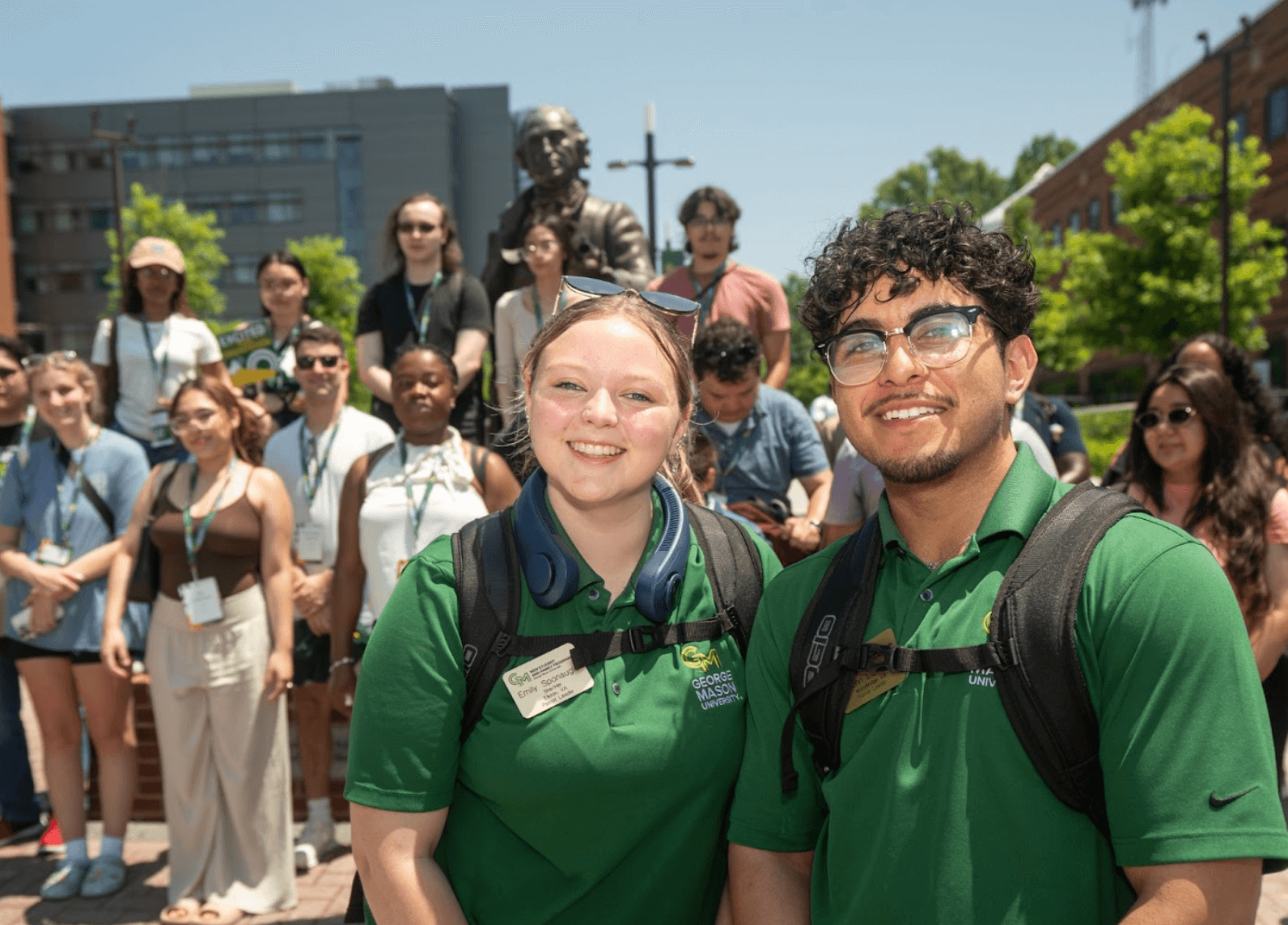 Two students wearing matching green polo shirts