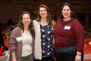 A group of three faculty and staff together at the Faculty and Staff Donor Breakfast event on the Fairfax Campus.
