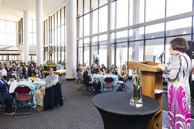 Kimmy Doung speaks at a podium at the George Mason University Scholarship Breakfast 2023. Photo by: Ron Aira/Creative Services/George Mason University