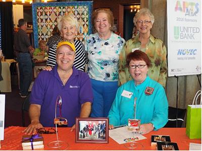 Dean Rick Davis,Penny Barrows, Claire Machosky-Ullman, Sue Farris, and Mary Postma gather around a table for a group photo.