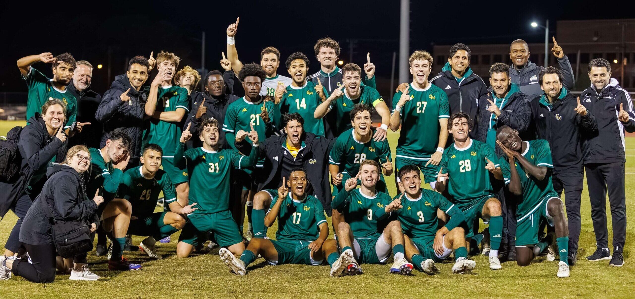 Mens soccer team posing and cheering together after winning the championship