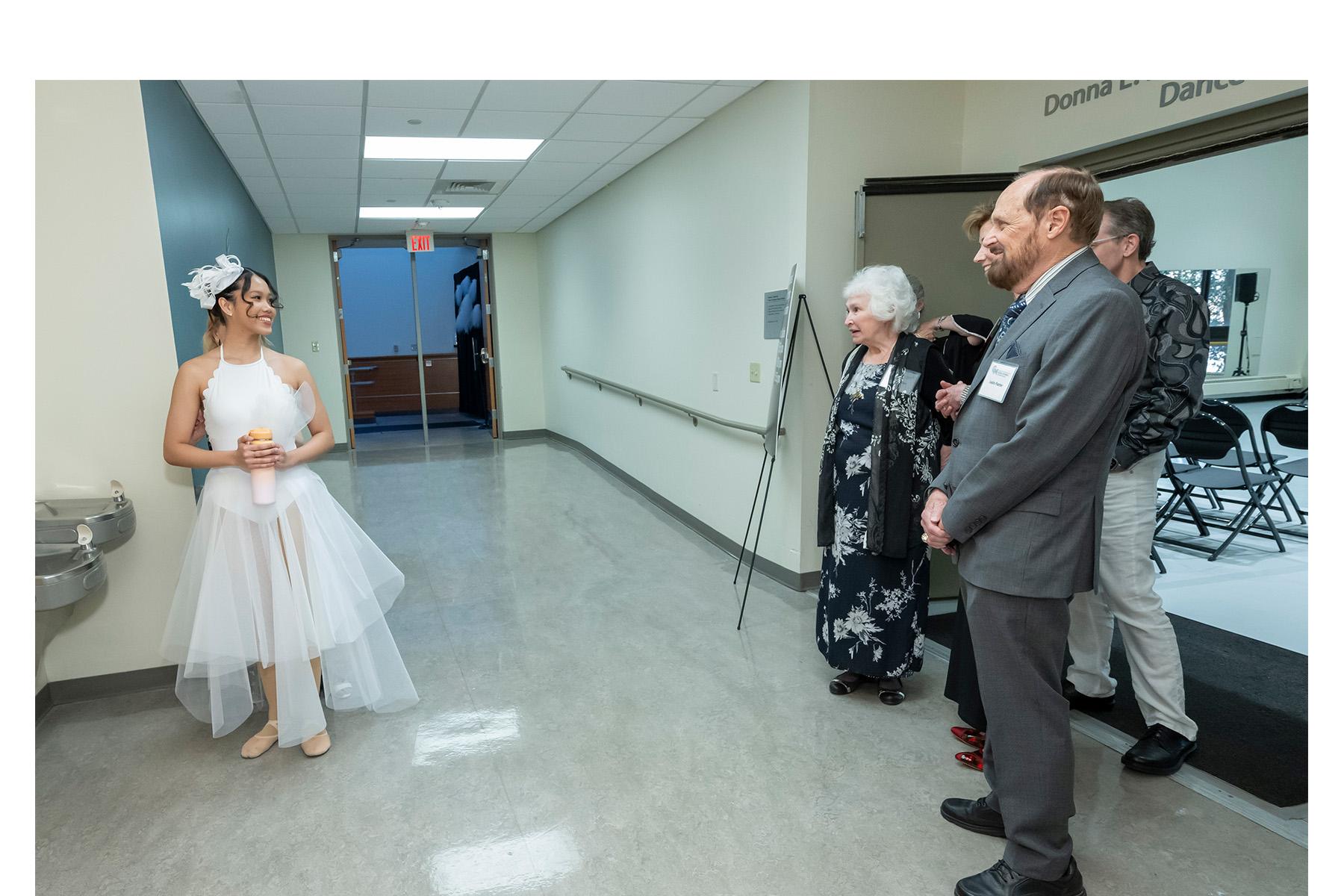 Dancer and four event attendees gathered in a hallway.