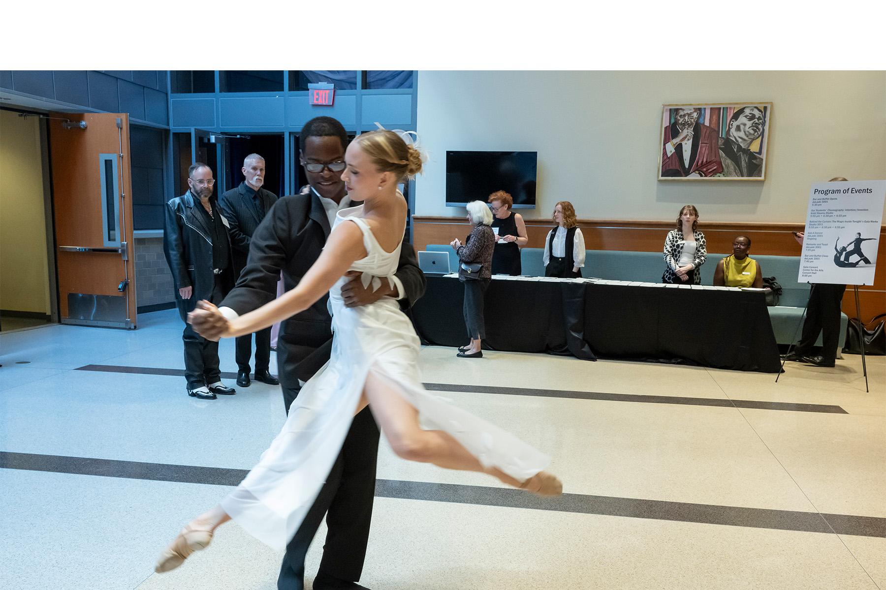 Two dancers perform in the event venue entrance.
