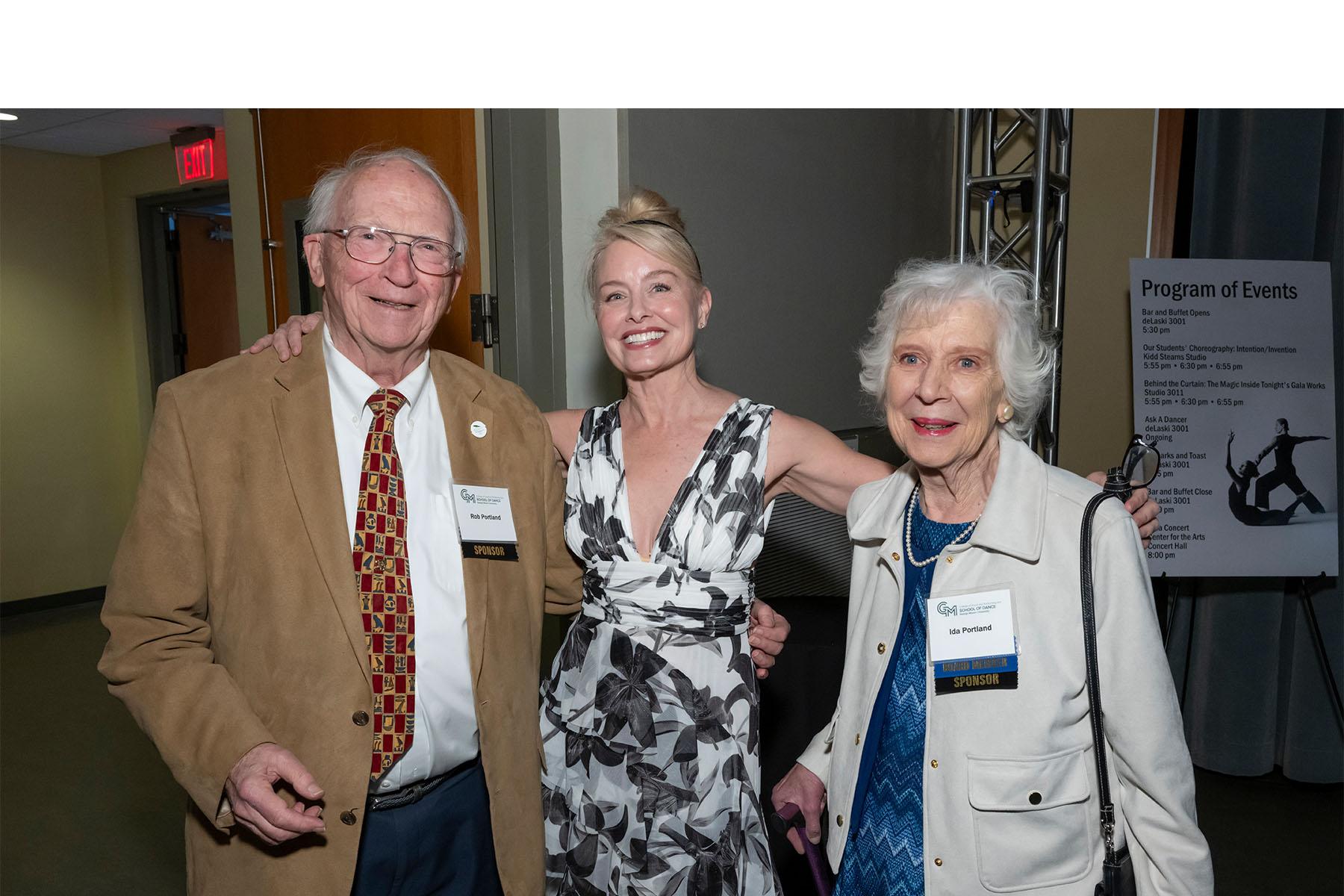 Three event attendees stand together.