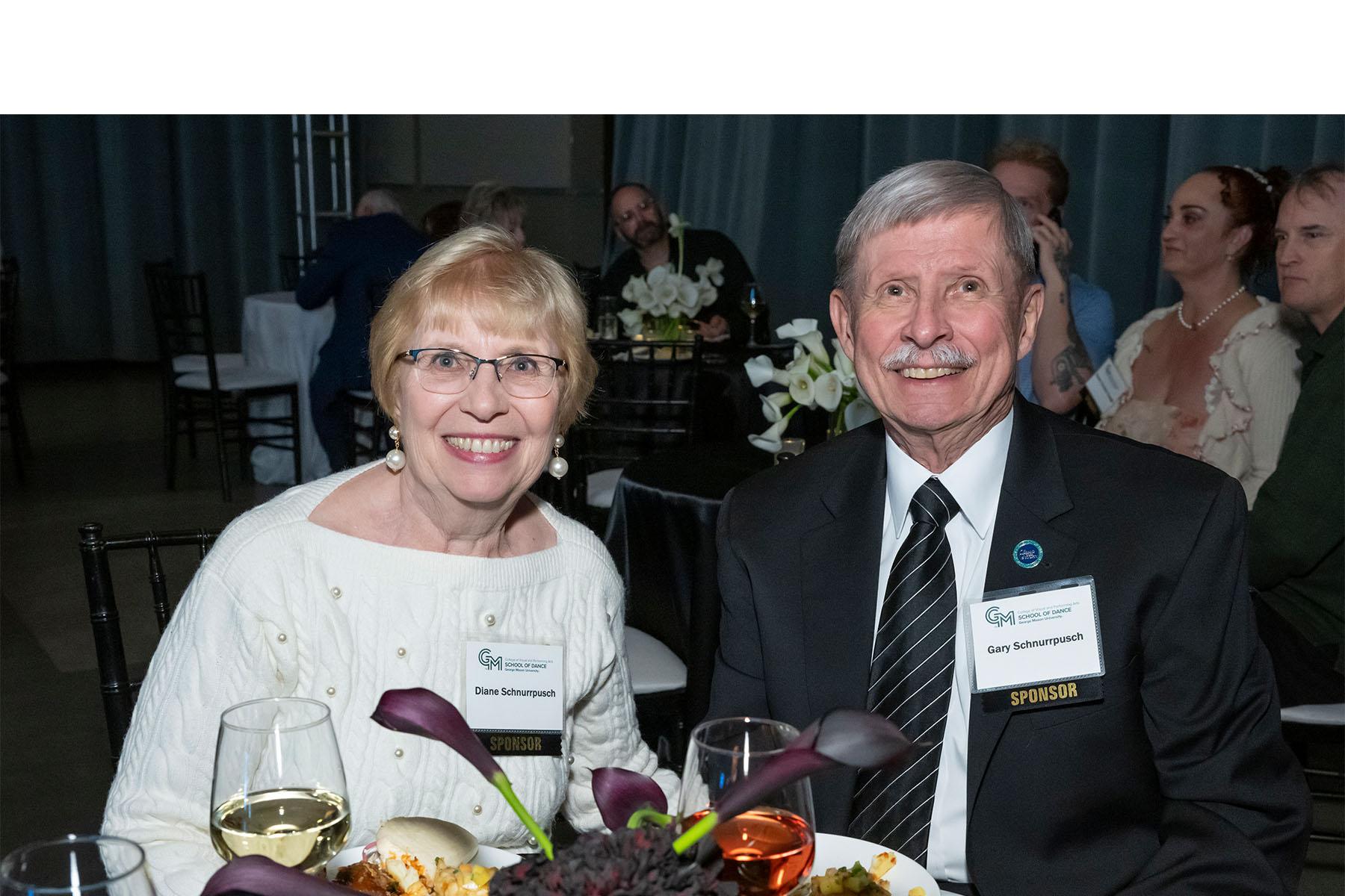 Two event attendees seated together at a table.