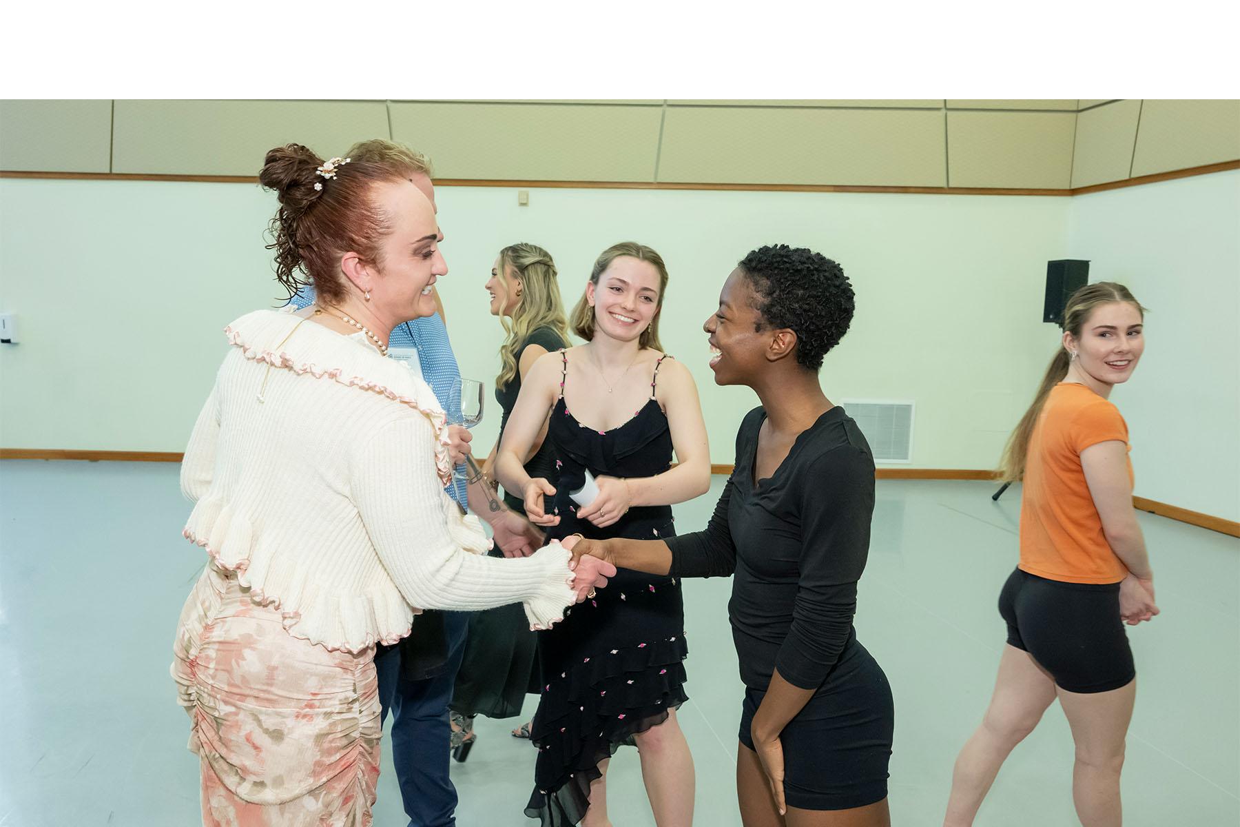 An event attendee speaking with two dancers.