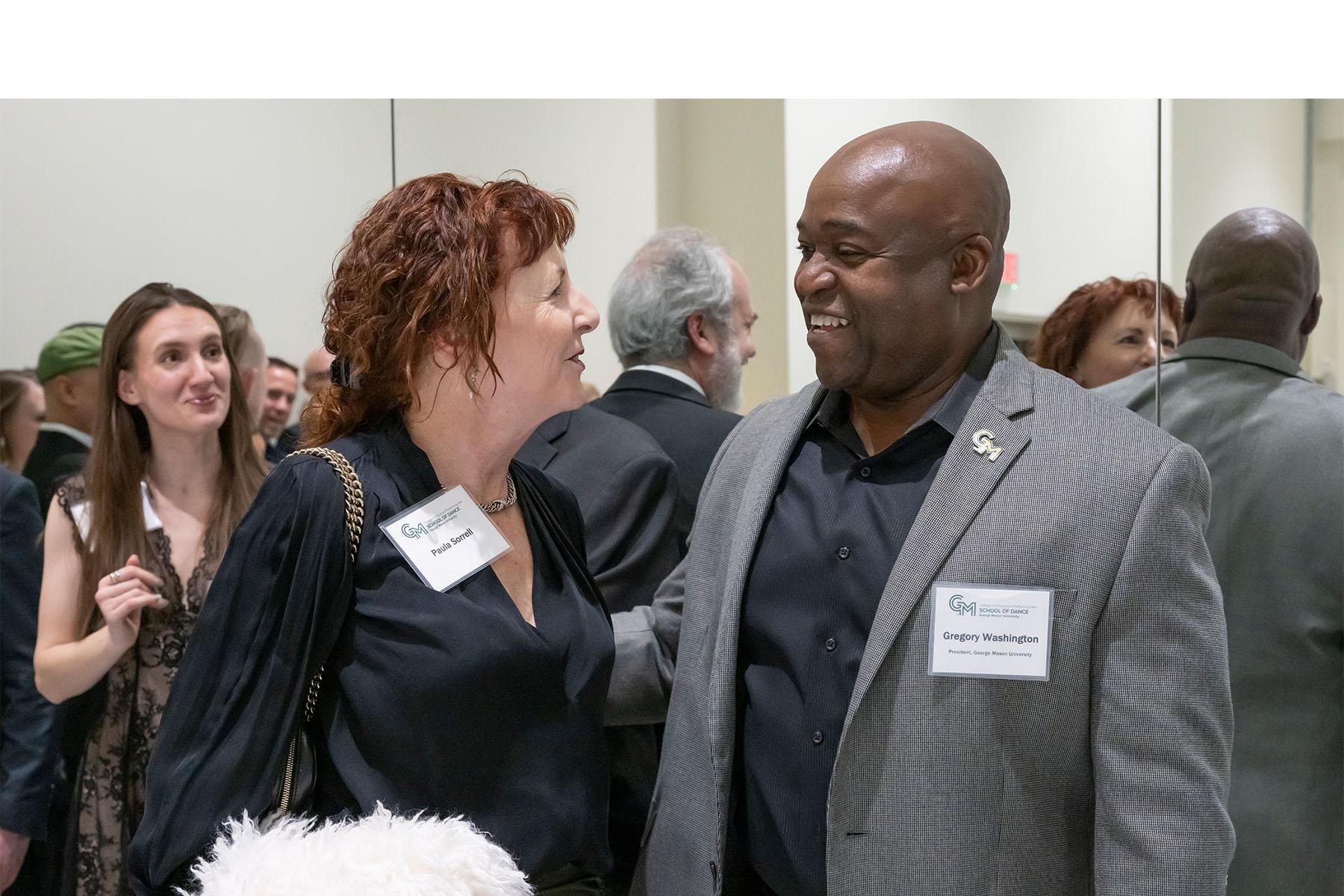 Two event attendees speaking with each other.