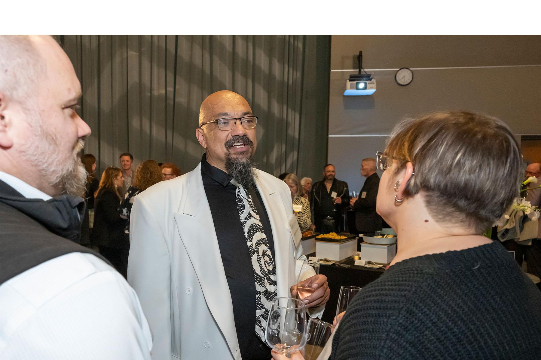 Three event attendees speaking with each other.