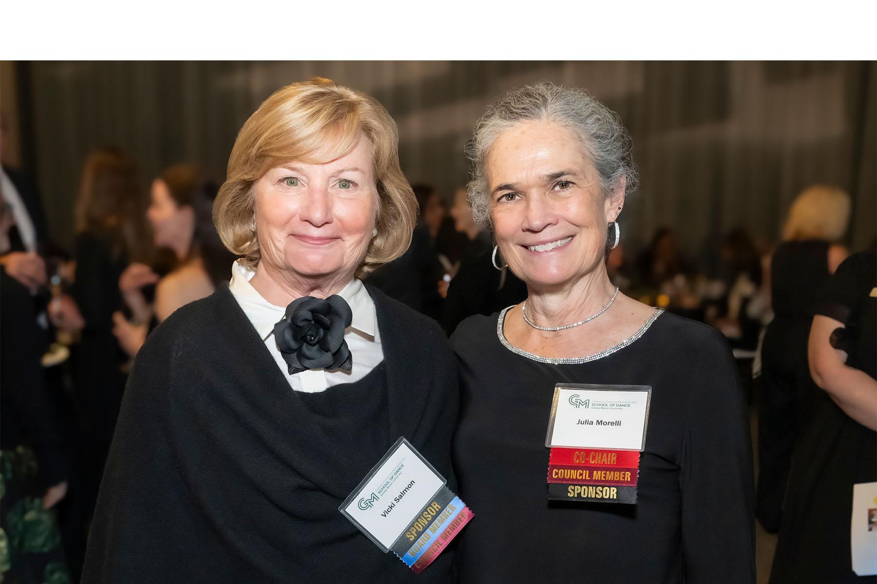 Two event attendees stand together.