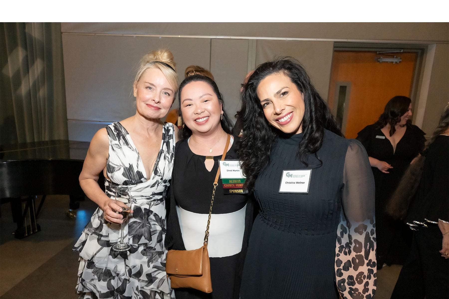 Three event attendees stand together.