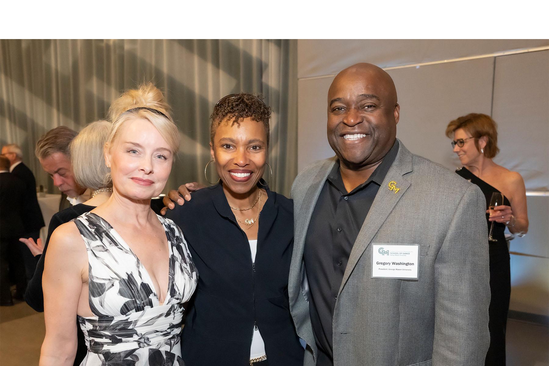 Three event attendees stand together.