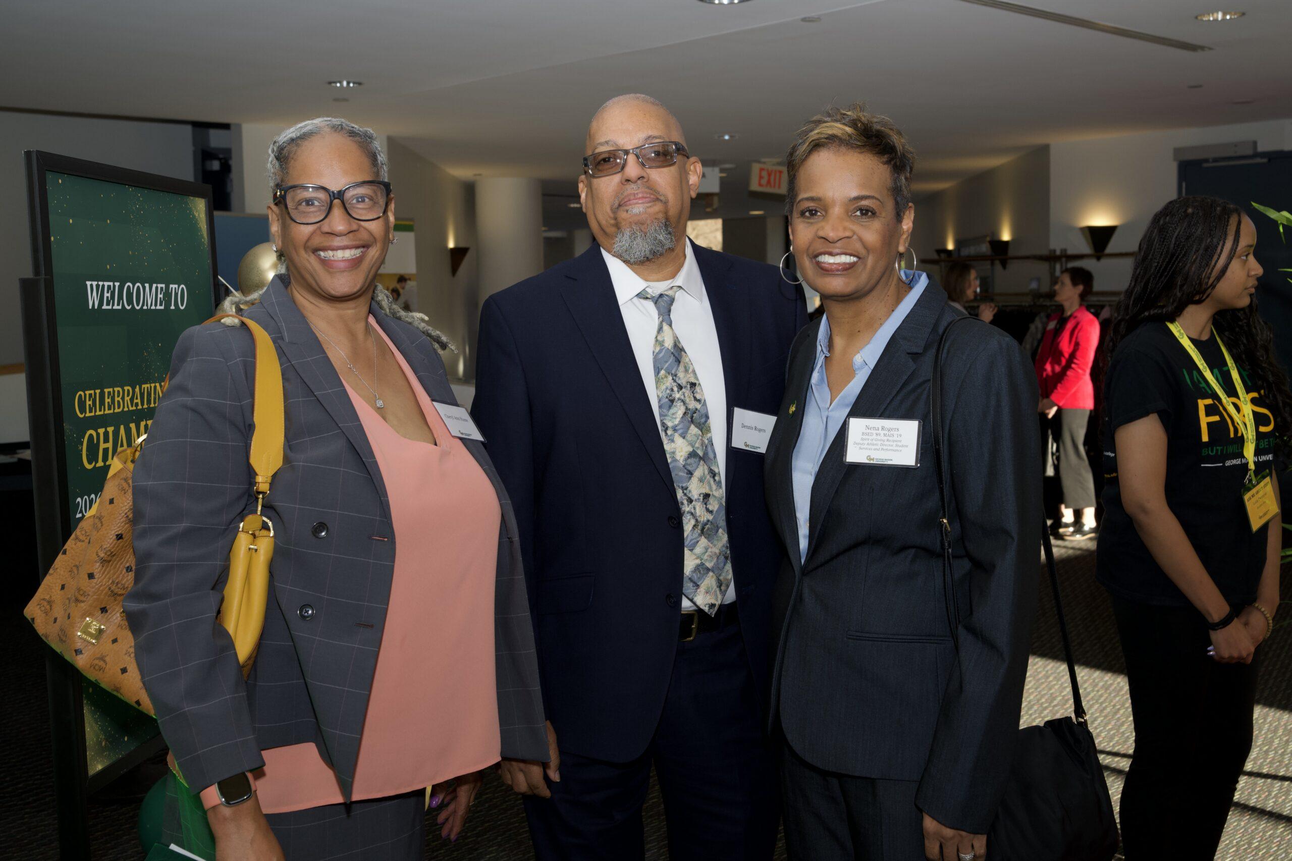 Three attendees stand together at Celebrating Our Champions event.