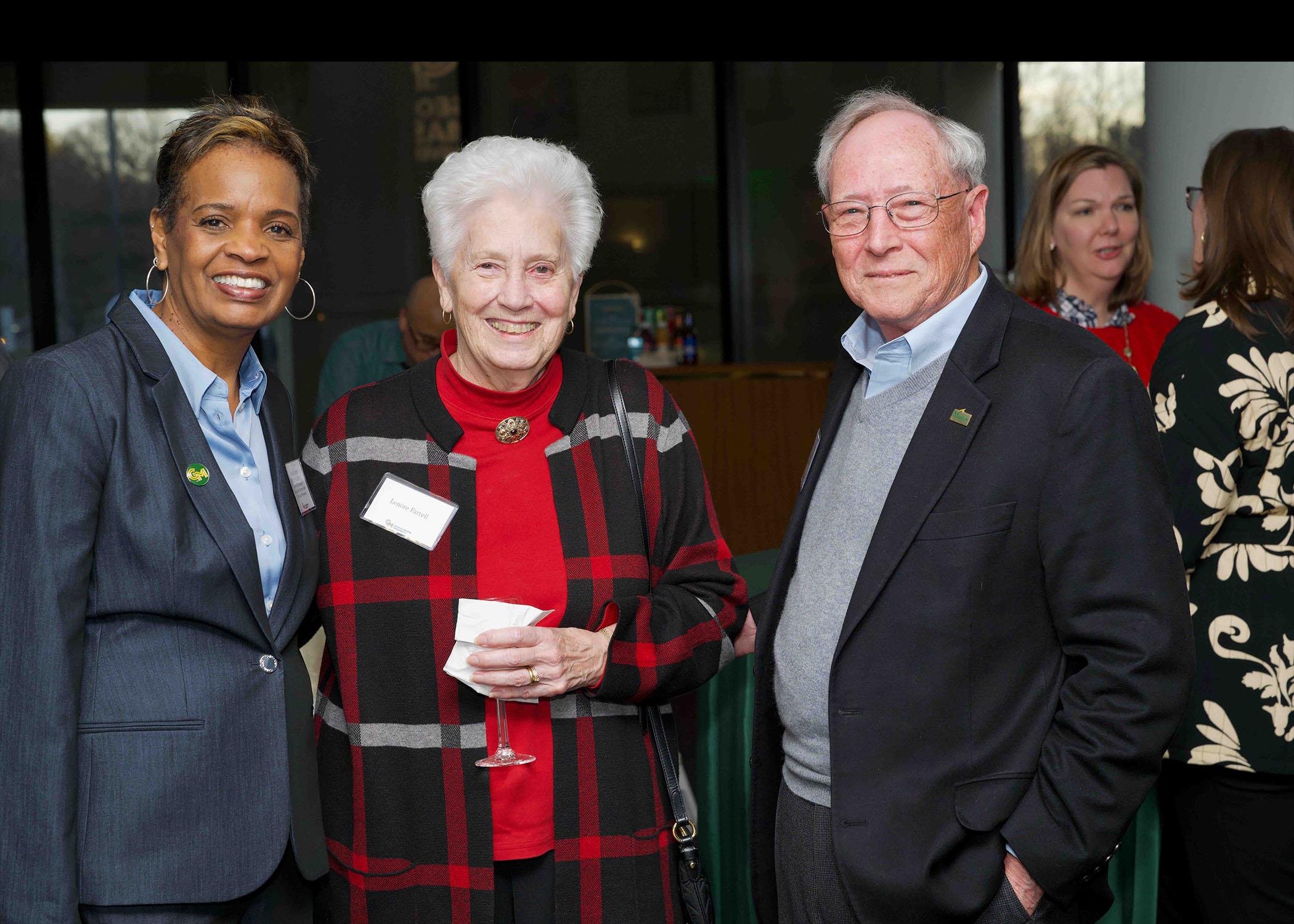Three attendees stand together at Celebrating Our Champions event.