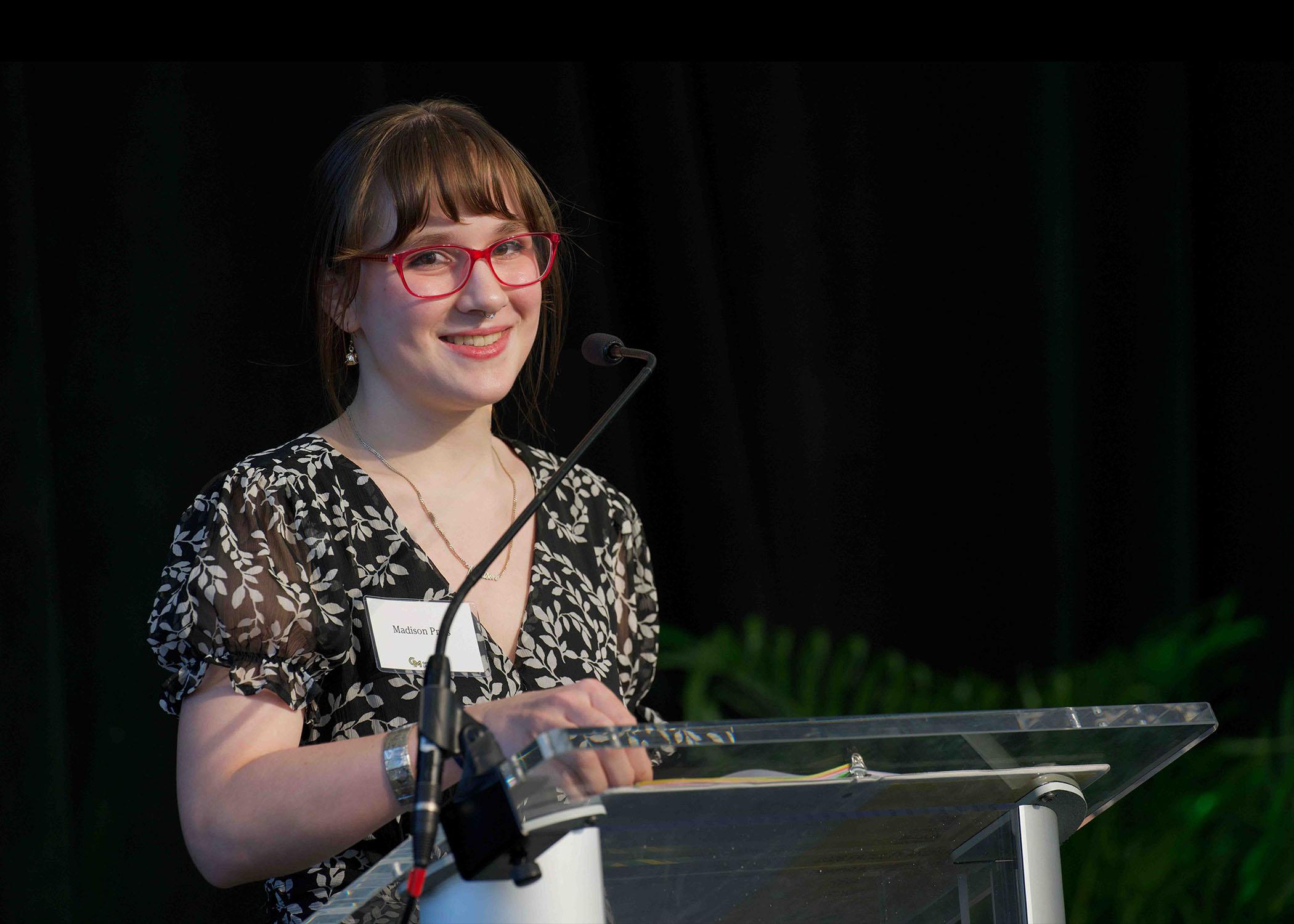 Madison Preis stands at podium at Celebrating Our Champions event.
