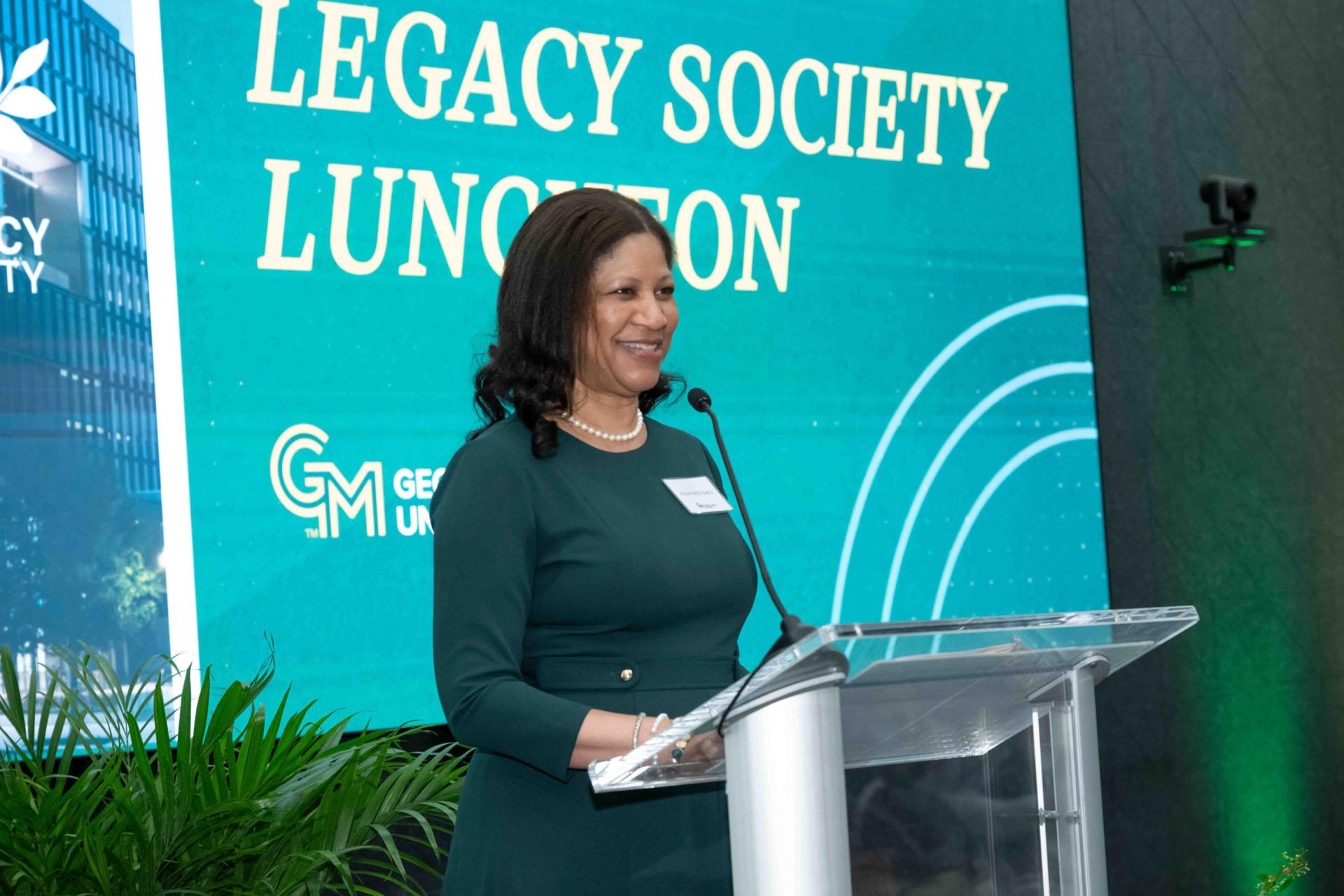 Event speaker stands at a podium to address the attendees.