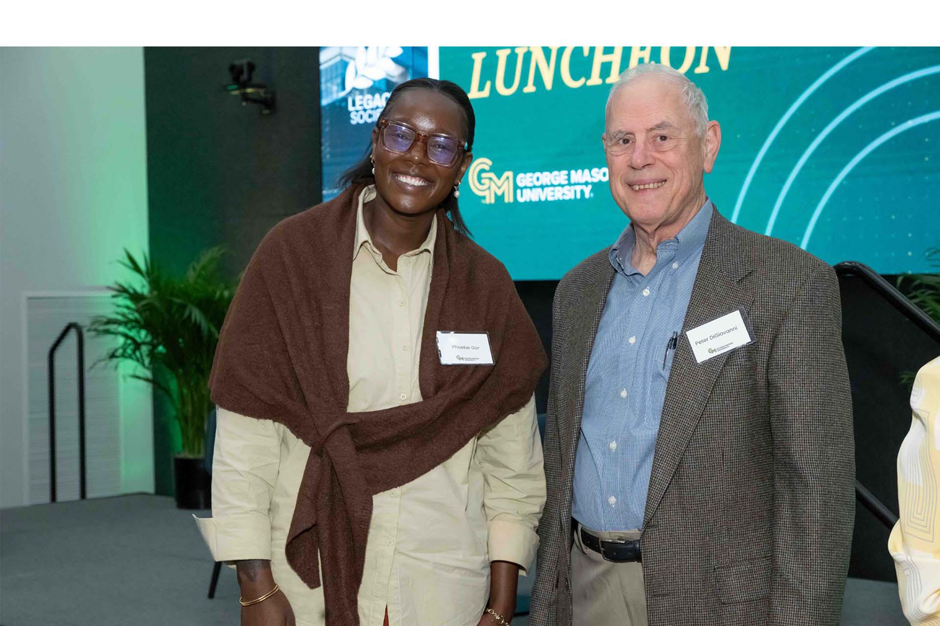 Two event attendees pose together in the reception space.