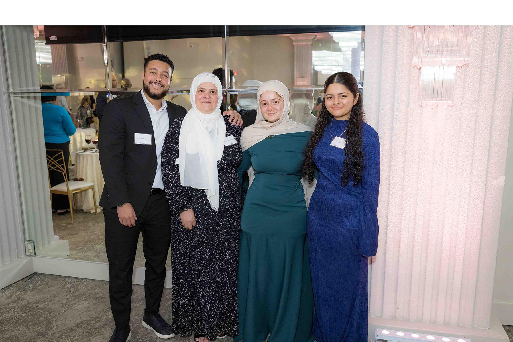 Four event attendees standing together in front of a mirrored wall.