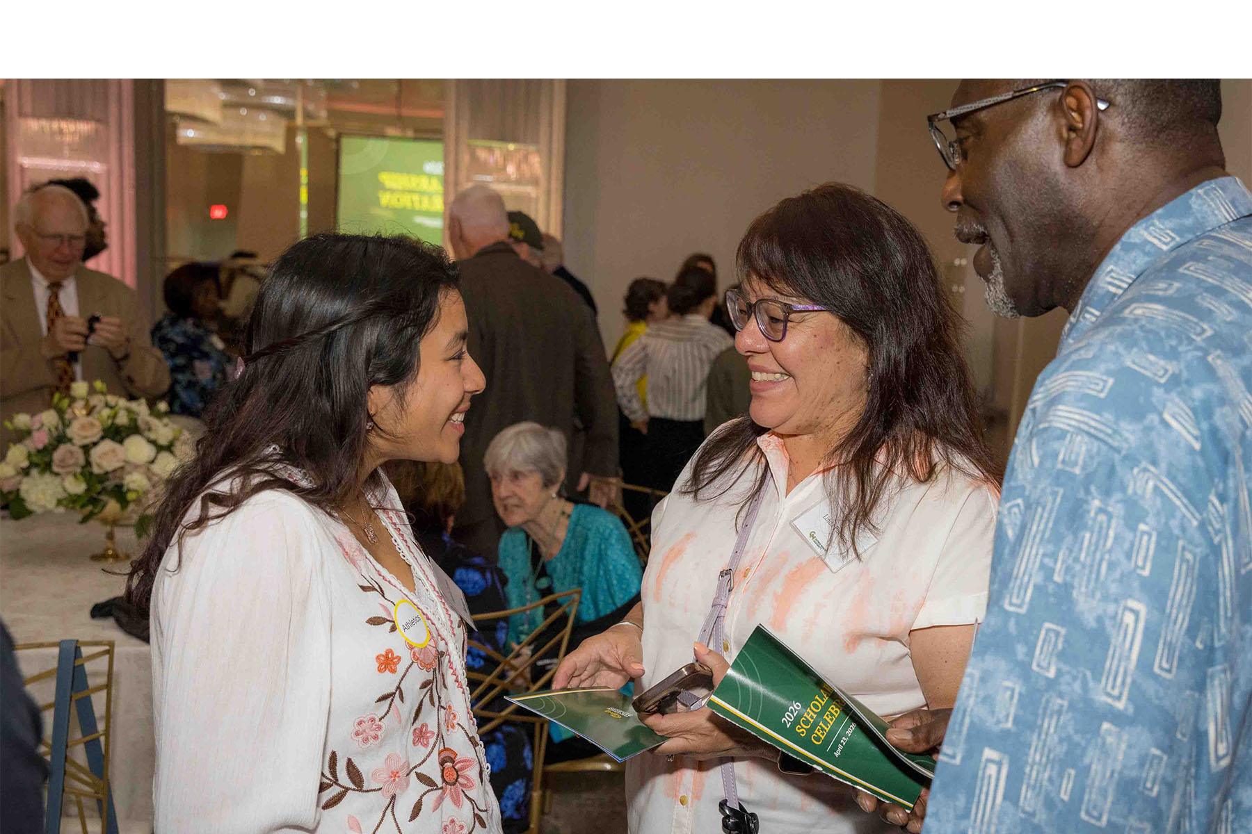 Three event attendees standing together in the reception area.