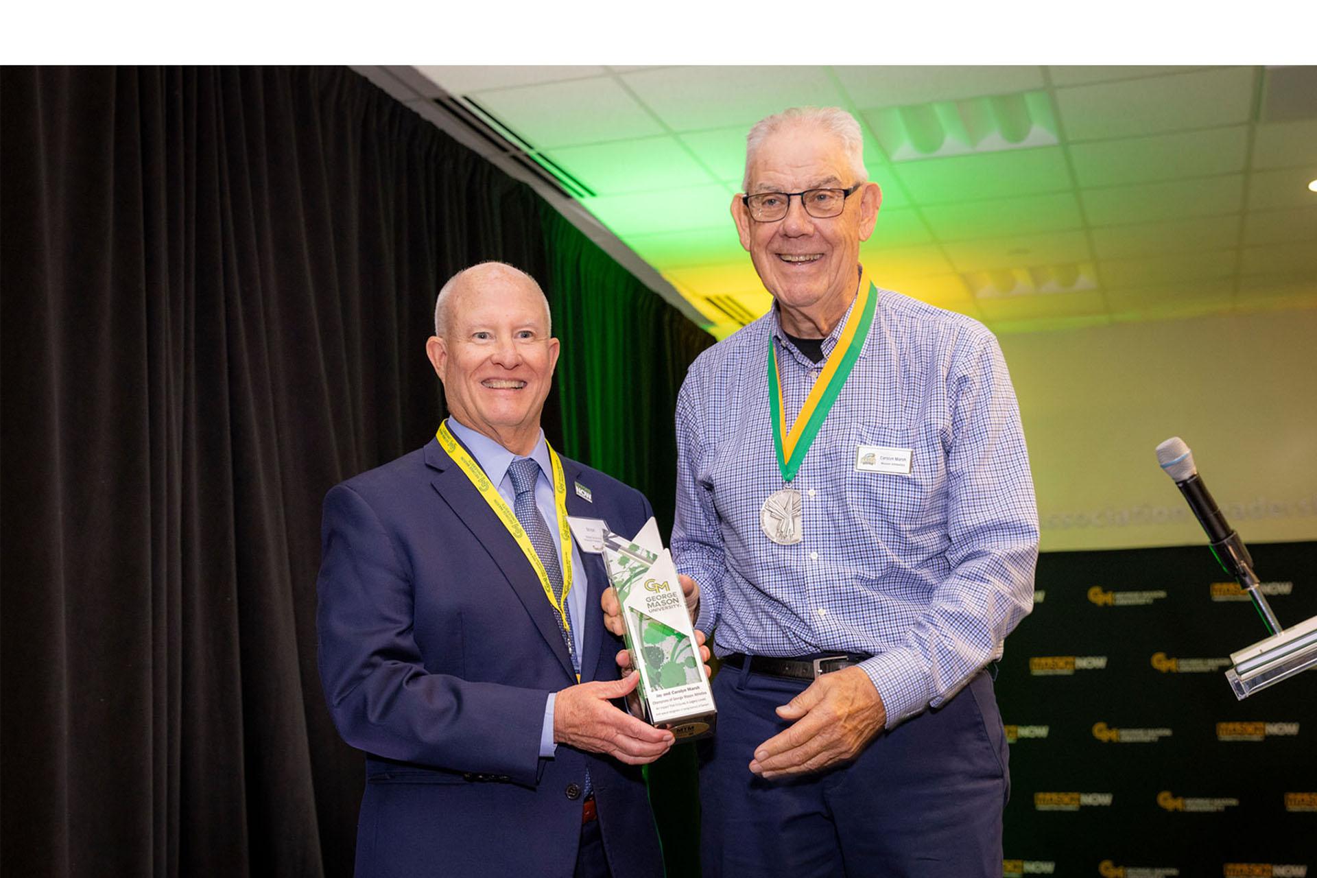 Brian Drummond and Jay Marsh pose together while holding an award.