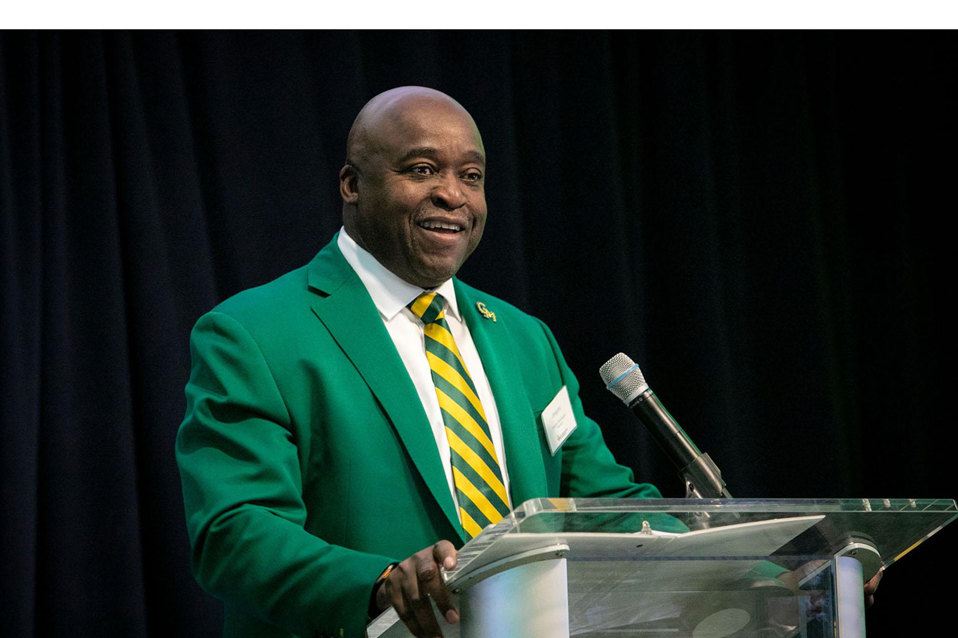 President Gregory Washington addresses attendees on stage at a podium.