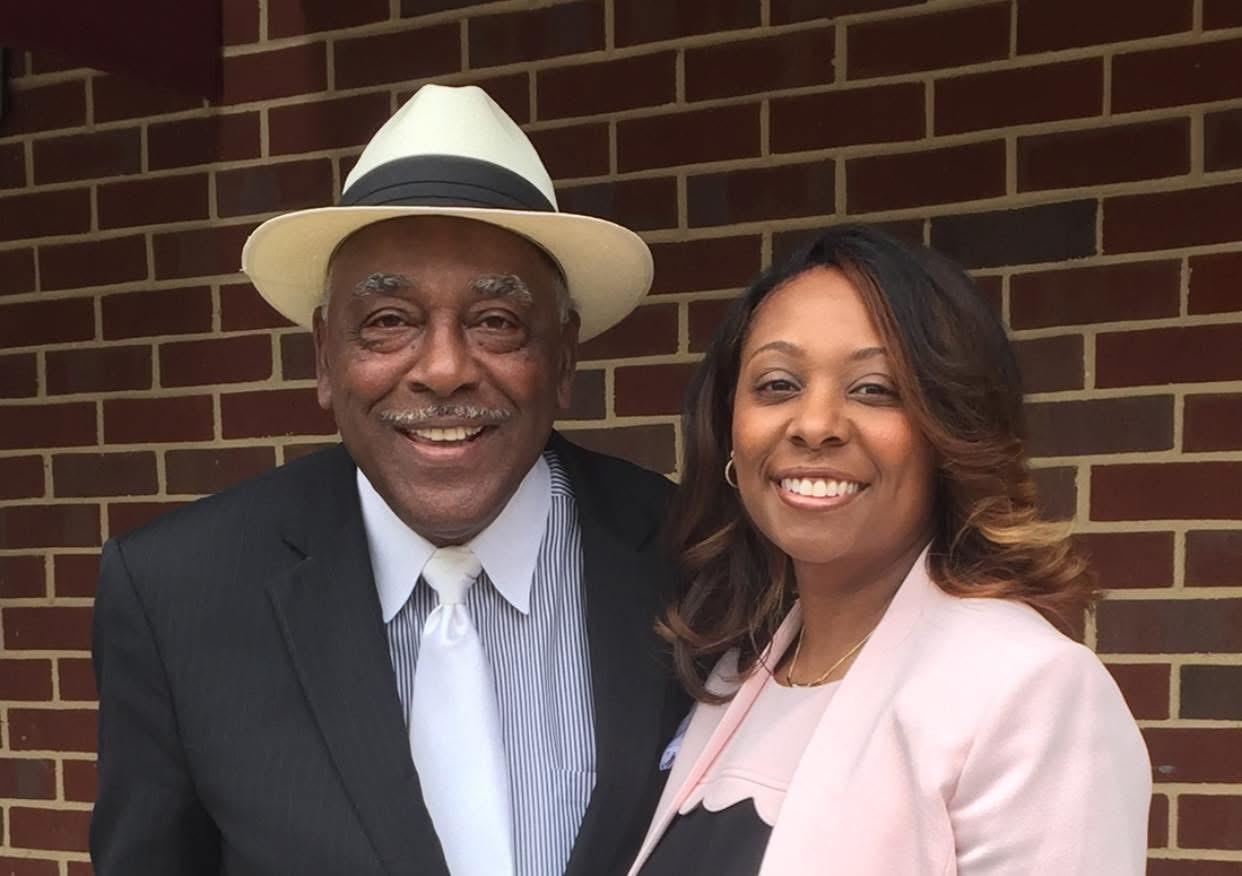 Shawn Chambliss Purvis and her father, Spencer Chambliss Senior standing together in front of a brick wall.